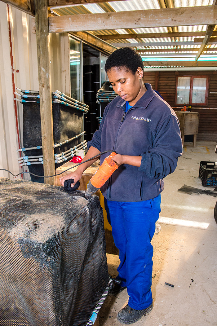 An AquaWomen team member assembling an abalone basket in the Hermanus workshop